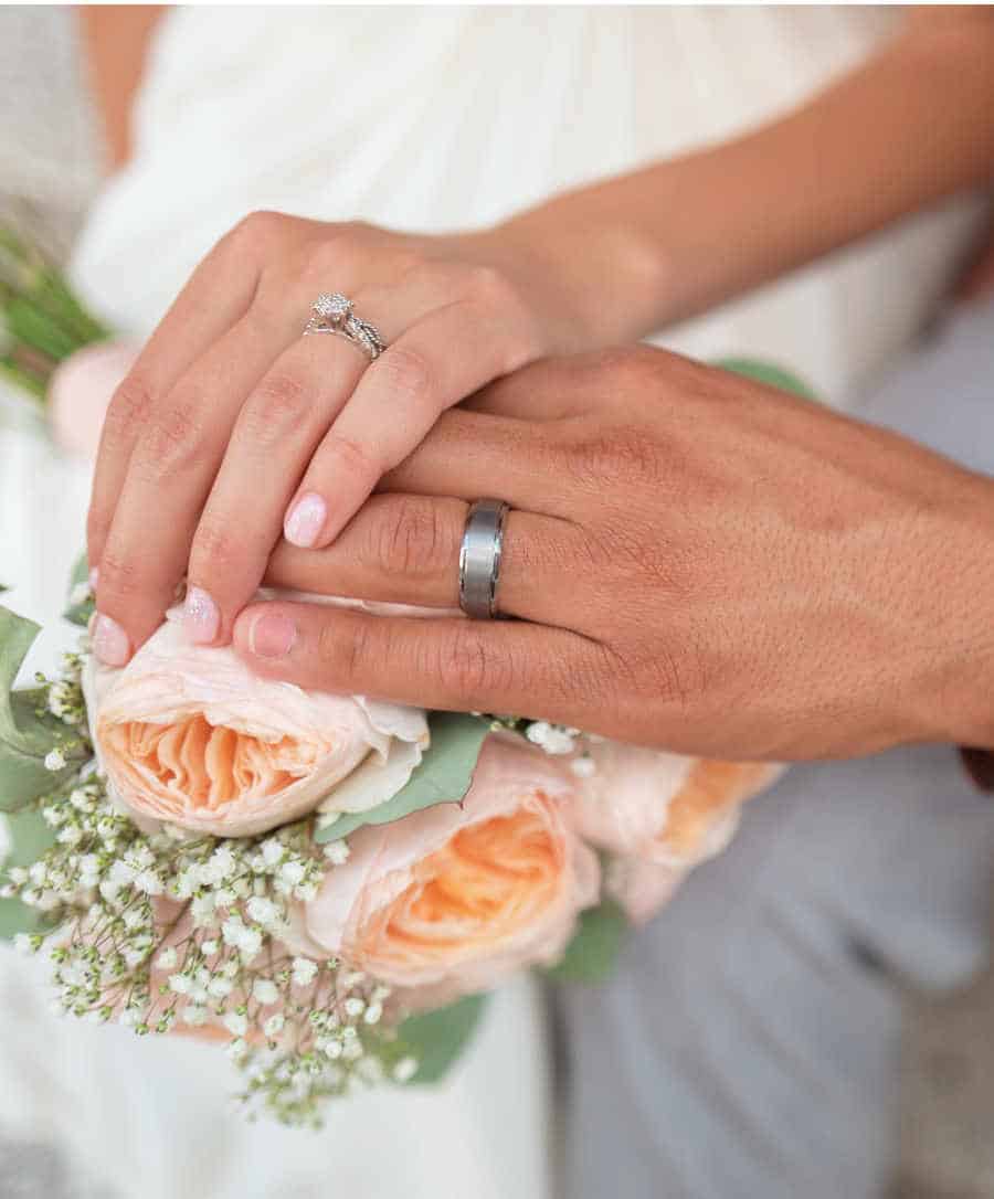 Woman and man holding hands showing their wedding rings