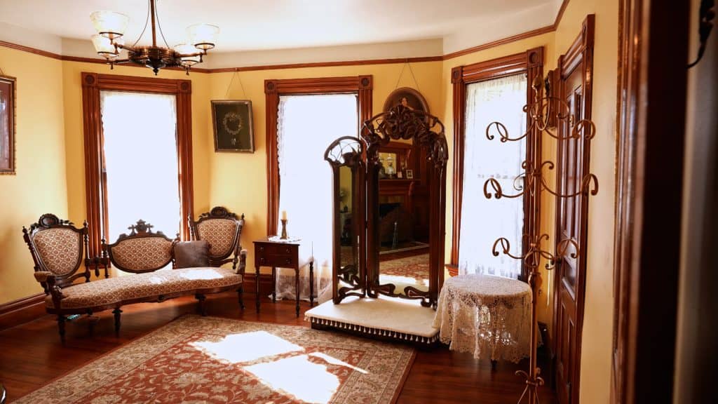 The second floor dressing room of the Victorian Belle Mansion arranged with antique furniture and a three-way mirror
